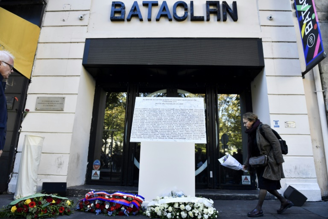 Une femme dépose des fleurs devant une plaque commémorative lors d'une cérémonie au Bataclan à Paris, sept ans après les attentats terroristes, le 13 novembre 2022 © JULIEN DE ROSA