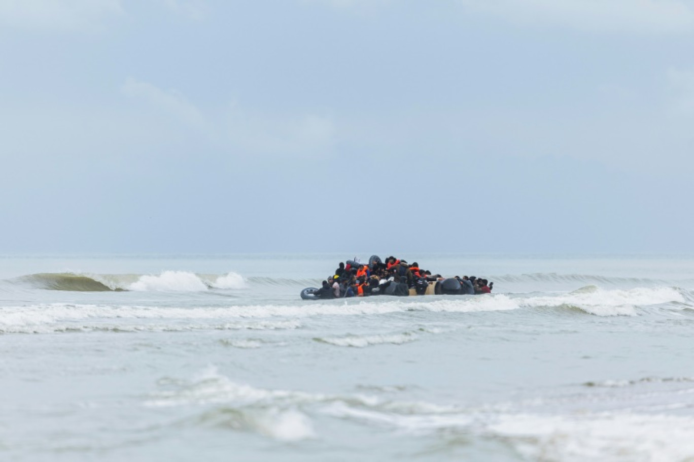 Des migrants se pressent sur un canot pneumatique pour tenter de traverser la Manche, après avoir quitté la plage de l'Ecault à Saint-Etienne-au-Mont, près de Neufchâtel-Hardelot, dans le Pas-de-Calais, le 30 octobre 2024 © Sameer Al-DOUMY