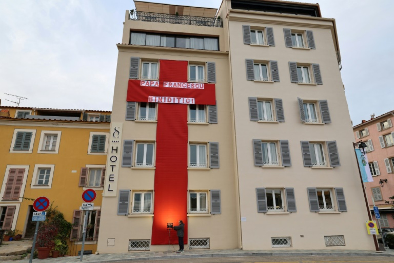 Une immense croix rouge en tissu accrochée à la façade d'un hôtel pour la visite du pape François à Ajaccio, le 12 décembre 2024 en Corse © PASCAL POCHARD-CASABIANCA