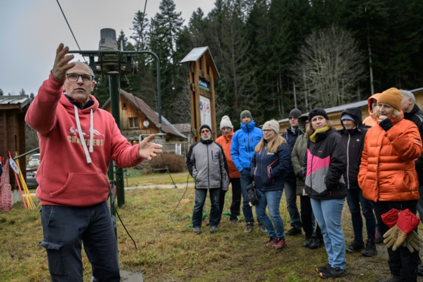 Bruno Cottave (g), de l'association "Nouvelles traces en Chartreuse", explique à des bénévoles le fonctionnement de l’un des cinq téléskis de la station du Planolet, le 7 décembre 2024 à Saint-Pierre-de-Chartreuse, en Isère © ARNAUD FINISTRE