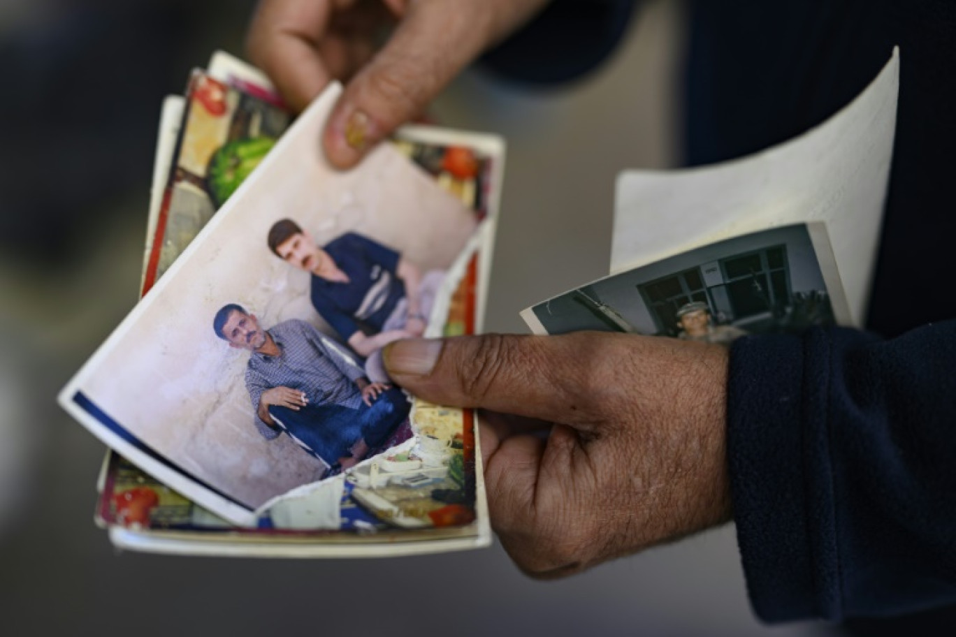 Le Turc Mehmet Erturk, tout juste libéré d'une prison syrienne, montre une photo de lui et de son ami Faruk Karga, lors d'un entretien avec l'AFP dans sa maison du village de Magaracik, le 13 décembre 2024 à Kilis, en Turquie © Yasin AKGUL