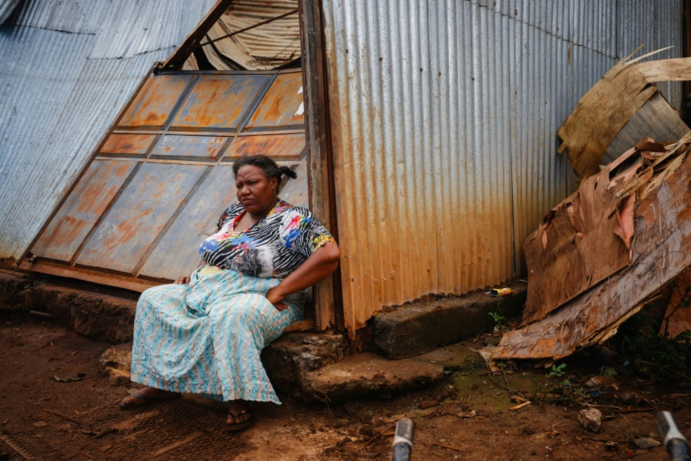 Une femme devant sa boutique détruite dans le village de Bouyouni à Mayotte le 19 décembre 2024 © DIMITAR DILKOFF