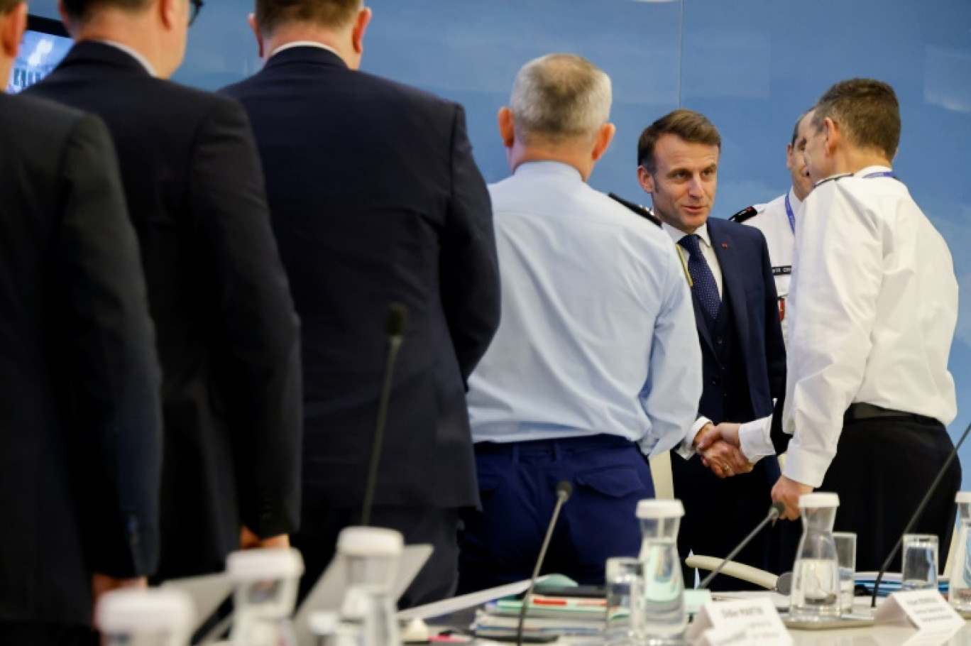 Le président Emmanuel Macron s'entretient avec des sauveteurs et des pompiers lors de sa visite du quartier de Cavani à Mamoudzou, après le passage du cyclone Chido à Mayotte, le 19 décembre 2024 © Ludovic MARIN