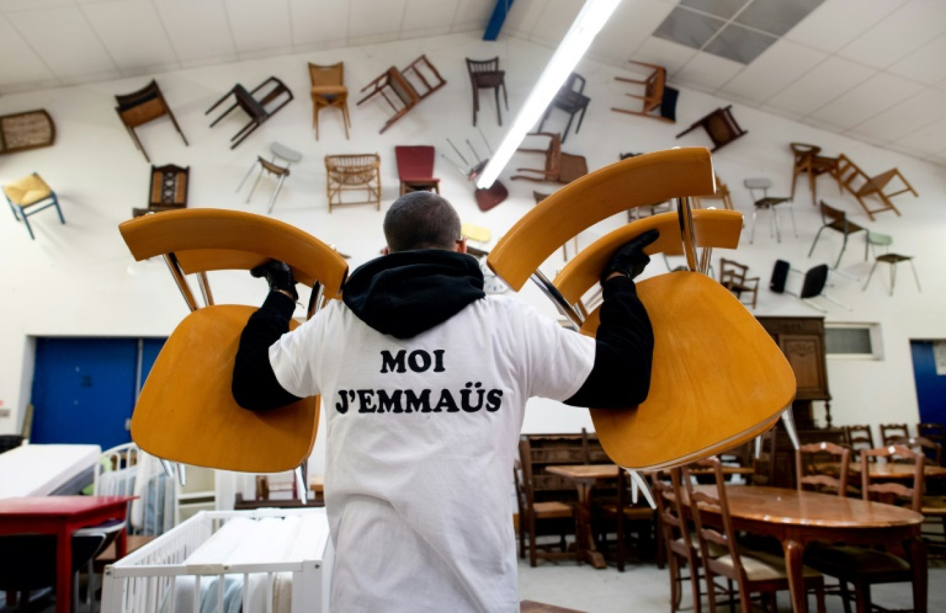 An employee of Emmaus Community carries chairs to tidy up at an Emmaus second-hand store in Brest, on May 30, 2023. Emmaus community collects furniture, ornaments, textiles and electrical devices donated by people and resell them at reasonable prices. © Fred TANNEAU