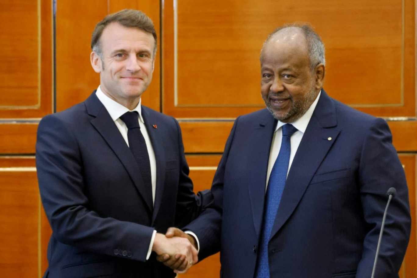 Le président français Emmanuel Macron (g) serre la main de son homologue djiboutien Ismaïl Omar Guelleh le 21 décembre 2024 à Djibouti © Ludovic MARIN