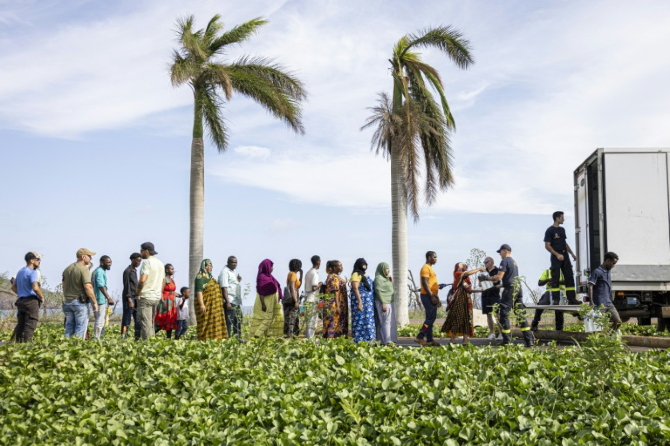 Des habitants attendent une distribution d'eau à Mamoudzou, le 23 décembre 2024, sept jours après le passage du cyclone Chido à Mayotte © PATRICK MEINHARDT