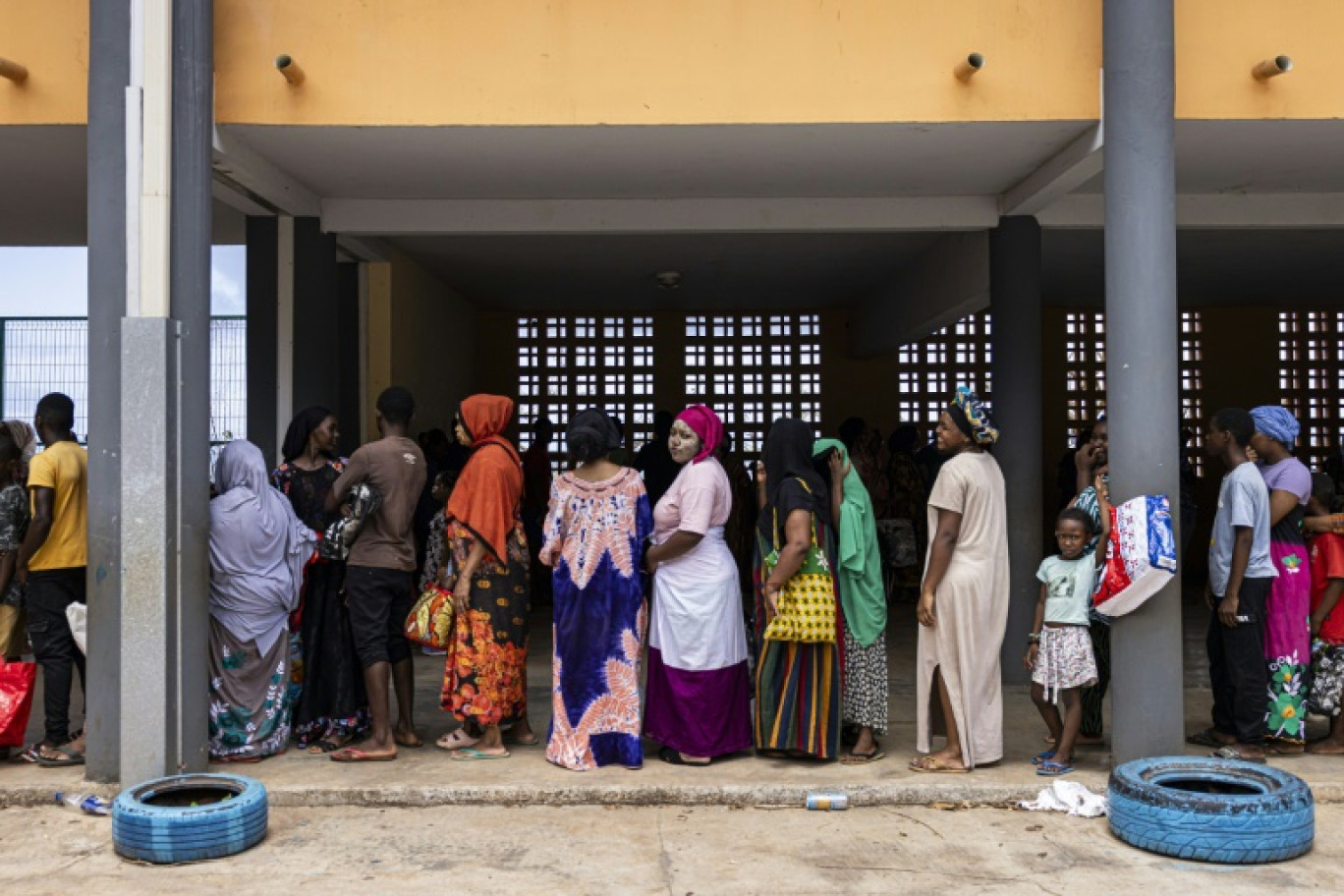 Des habitants de Mayotte font la queue pour recevoir de la nourriture et de l'eau lors d'une distribution à Mtsahara, le 25 décembre 2024 © PATRICK MEINHARDT