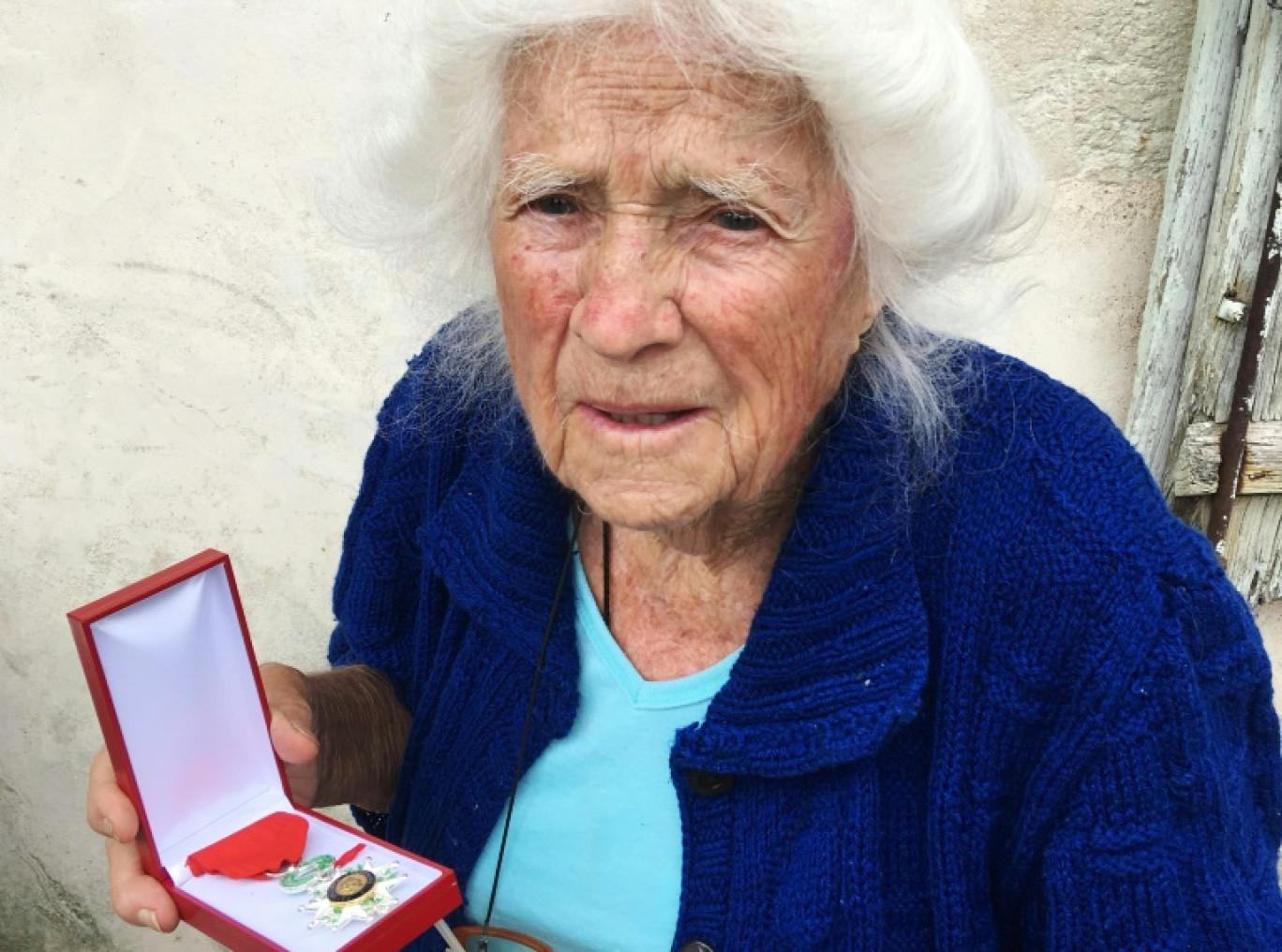 Geneviève Callerot, 102 ans, pose, le 25 août 2018 à Saint-Aulaye (Dordogne), avec sa Légion d'honneur dont elle a été décorée pour avoir fait passer en zone libre réfugiés et juifs durand la Seconde Guerre mondiale © MEHDI FEDOUACH