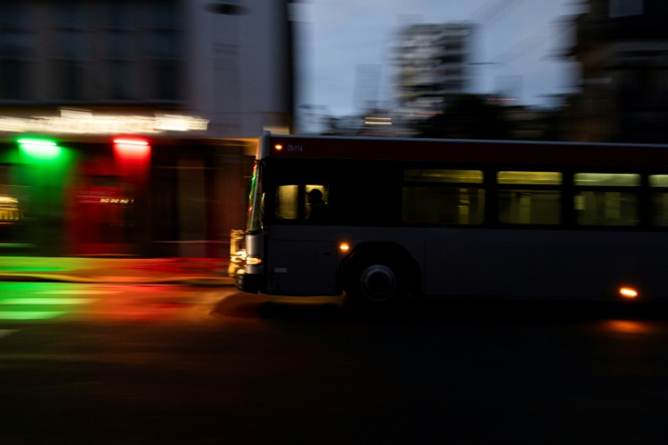 Un bus roule dans la ville de San Juan plongée dans l'obscurité, sur l'île de Puerto Rico après une panne géante d'électricité le 31 décembre 2024 © Ricardo ARDUENGO