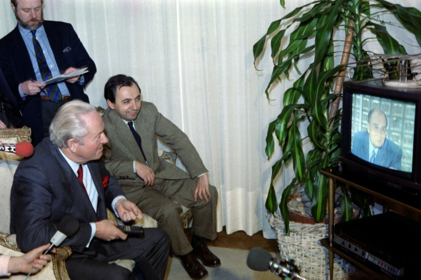 Le numéro un du Front national Jean-Marie Le Pen et Bruno Mégret, le numéro deux du mouvement, regardent le président François Mitterrand annoncer sa candidature à l'élection présidentielle à la télévision, le 22 mars 1988, dans sa maison de Saint-Cloud © PASCAL GEORGE