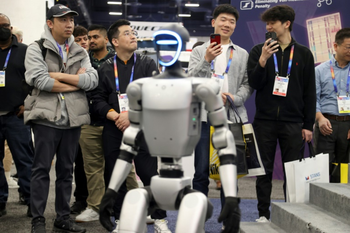 Attendees watch as a robot walks around during a demonstration at the Unitree Robotics booth during the Consumer Electronics Show (CES) in Las Vegas © Ian Maule