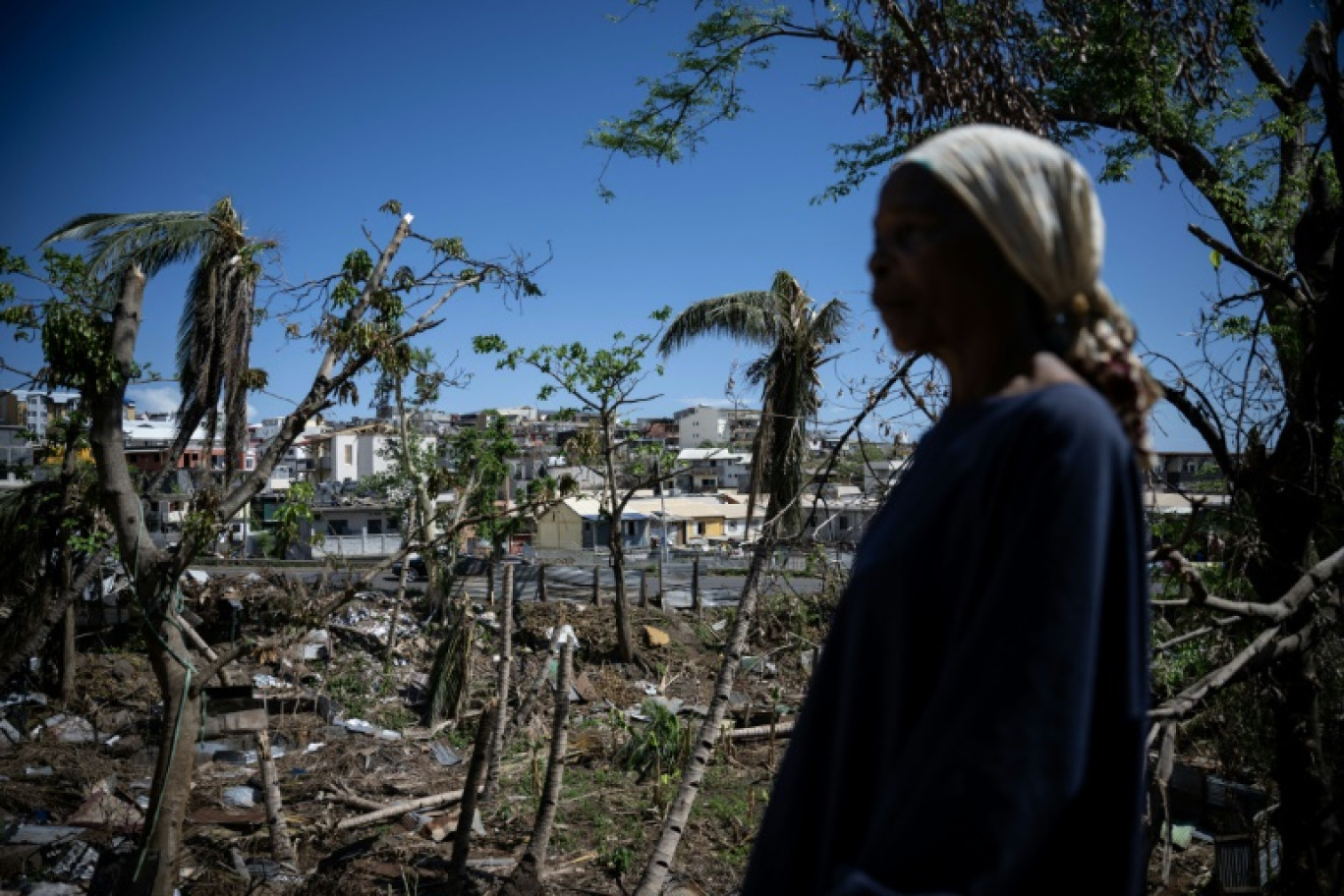 Une femme dans un bidonville détruit par le cyclone Chido à Mamoudzou, sur le territoire de Mayotte, le 31 décembre 2024 © JULIEN DE ROSA