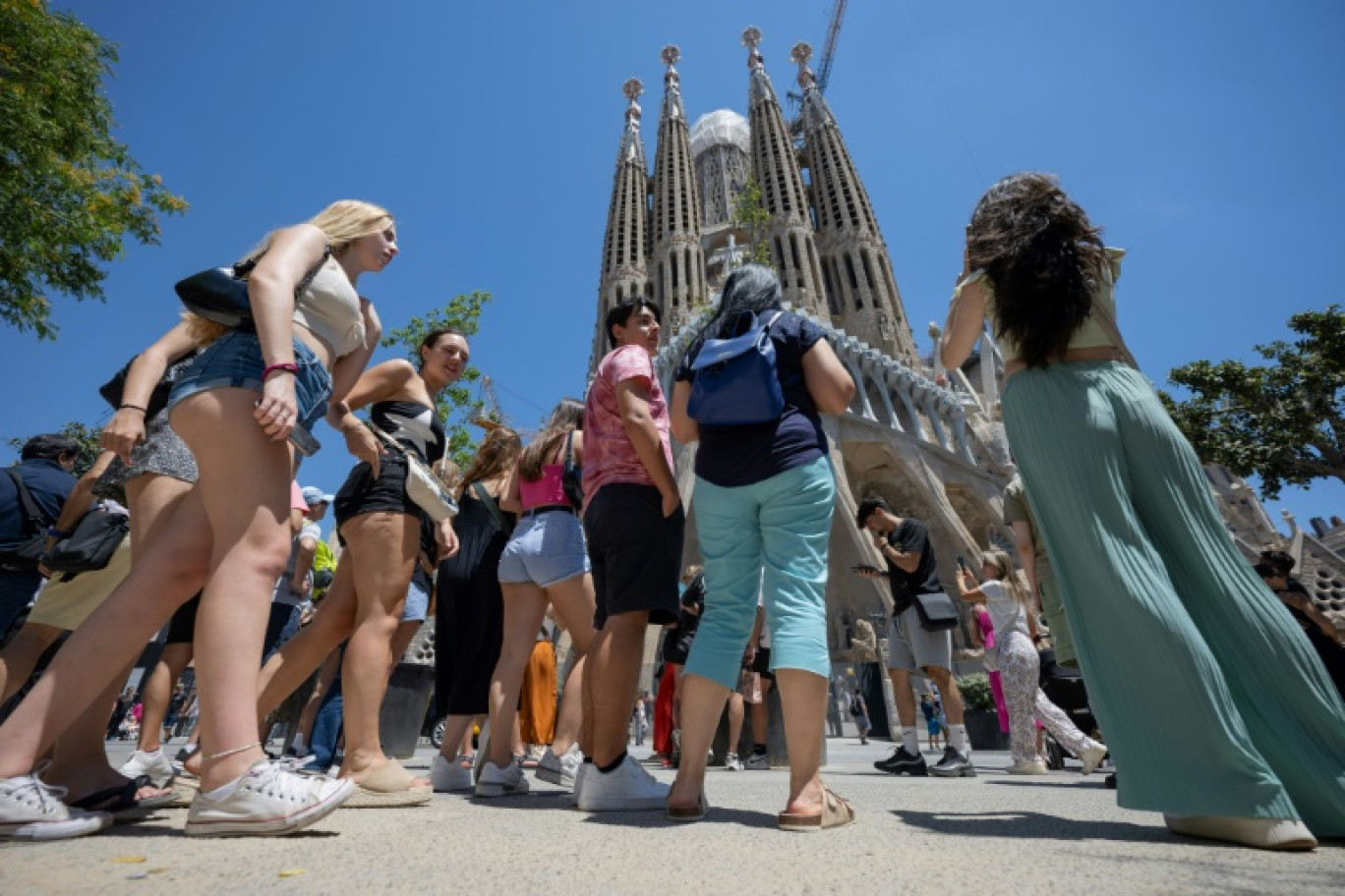 Des touristes devant la basilique Sagrada Familia à Barcelone le 5 juillet 2024 © Josep LAGO