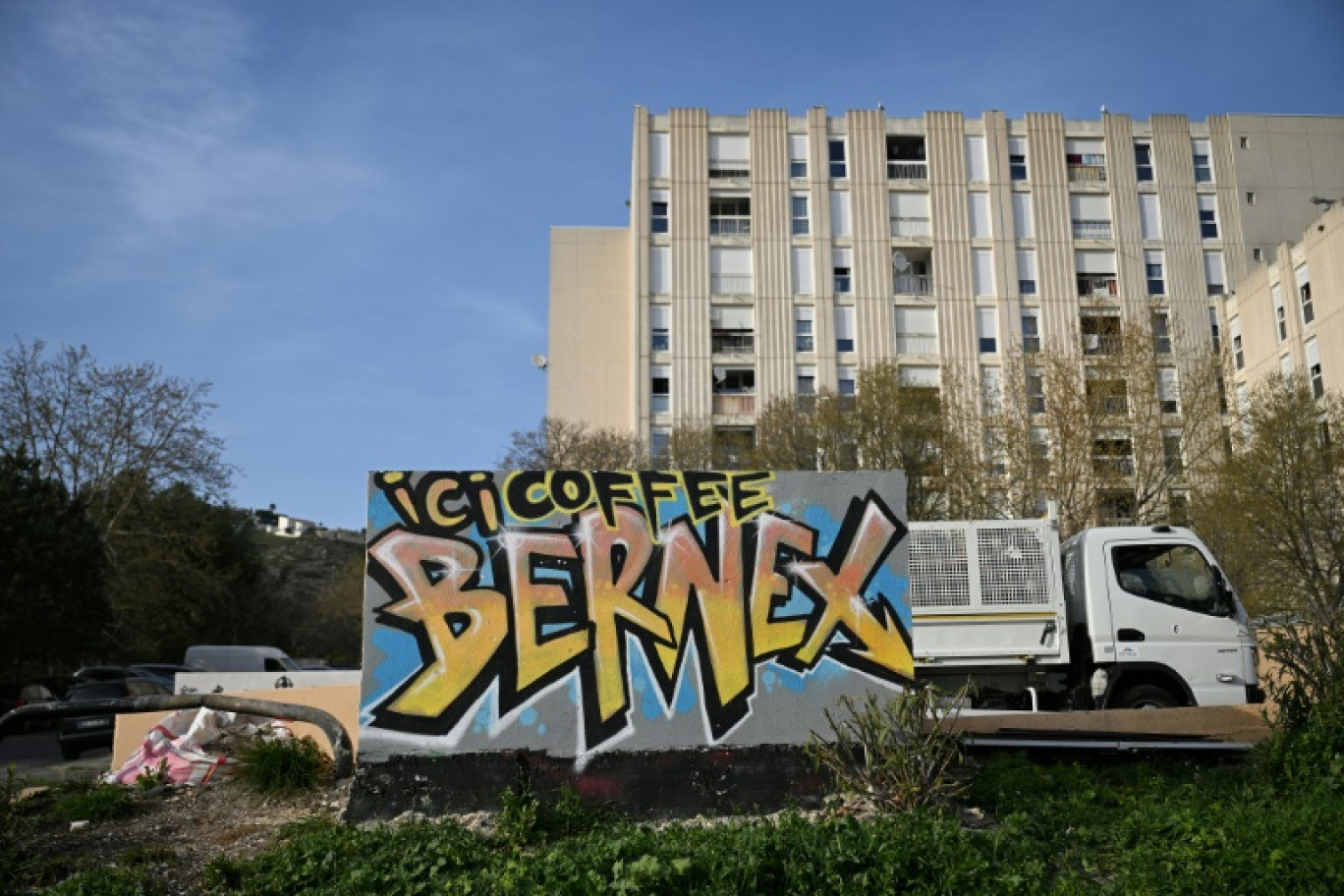 Un graffitt peint sur un mur indiquant l'emplacement d'un trafic de drogue (Here Coffee Bernex) dans le quartier de La Castellane, à Marseille, le 20 mars 2024 © NICOLAS TUCAT