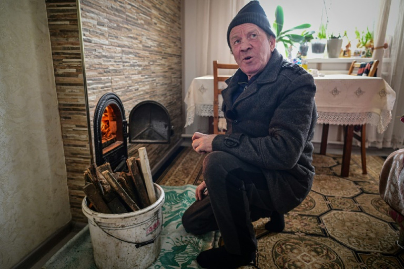 Valera Alexandru Sava allume le poêle dans sa maison de Cocieri, le 16 janvier 2025 en Moldavie © Daniel MIHAILESCU