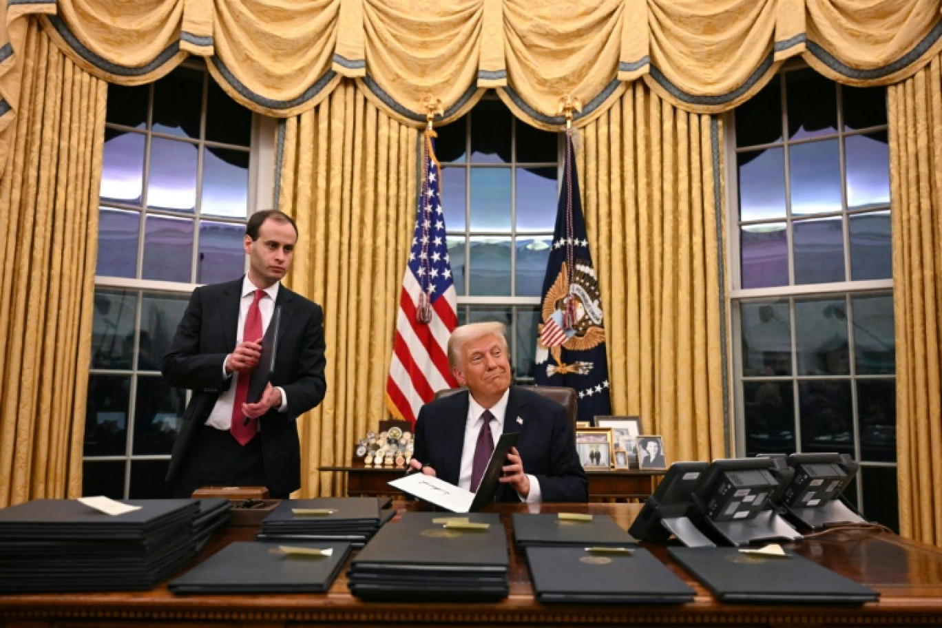 Le président américain Donald Trump signe des décrets dans le bureau ovale de la Maison Blanche, à Washington, le 20 janvier 2025 © Jim WATSON