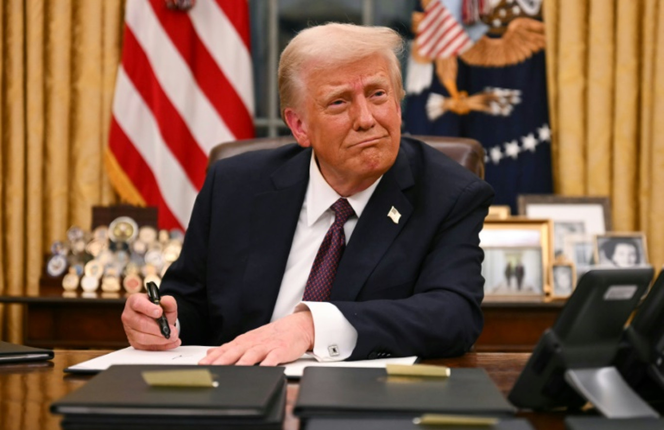 Le président américain Donald Trump signe des décrets dans le Bureau ovale de la Maison Blanche, le 20 janvier 2025 à Washington © Jim WATSON