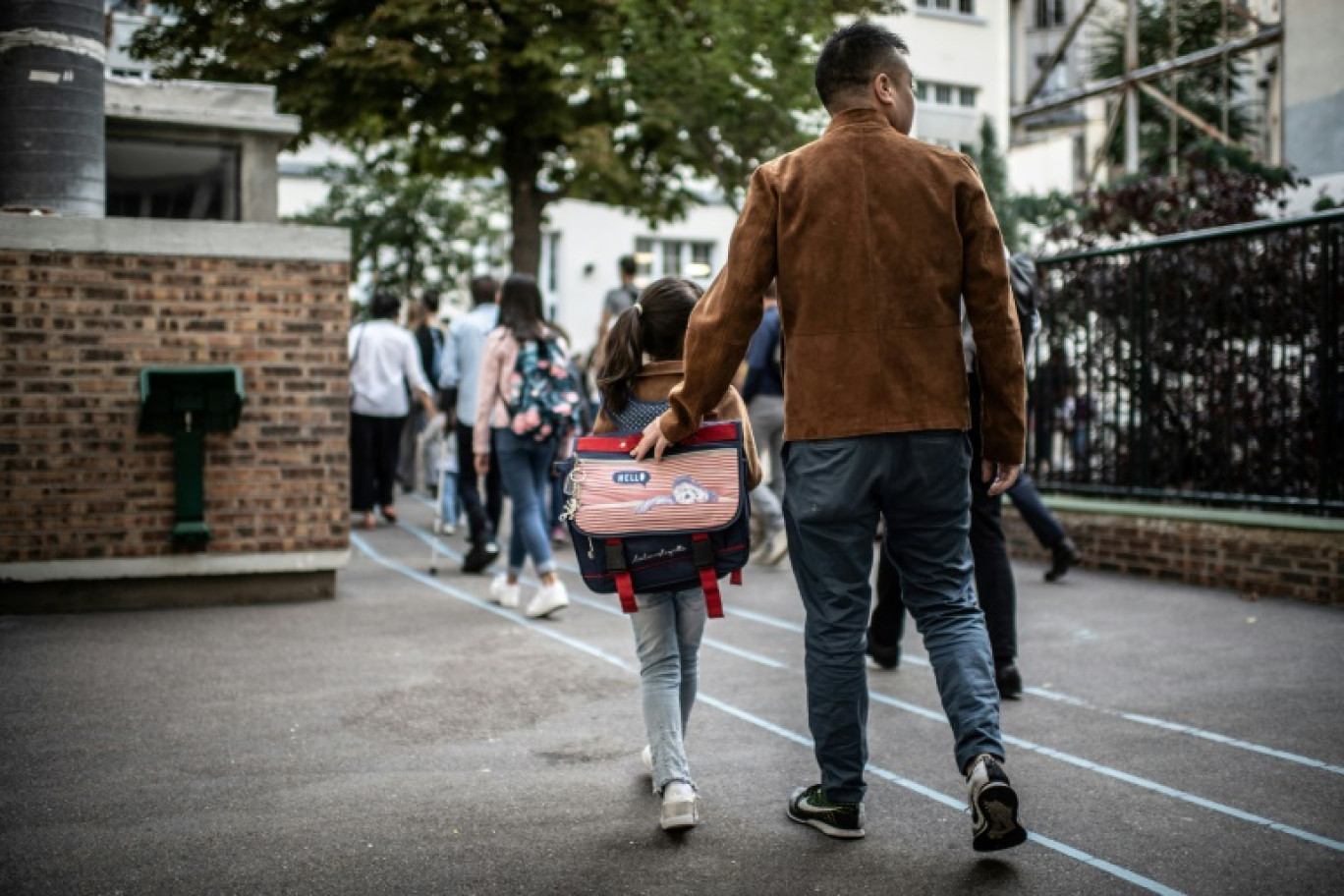 Un père accompagne sa fille à l'école  à l'occasion de la rentrée scolaire à Paris le 2 septembre 2019 © Martin BUREAU