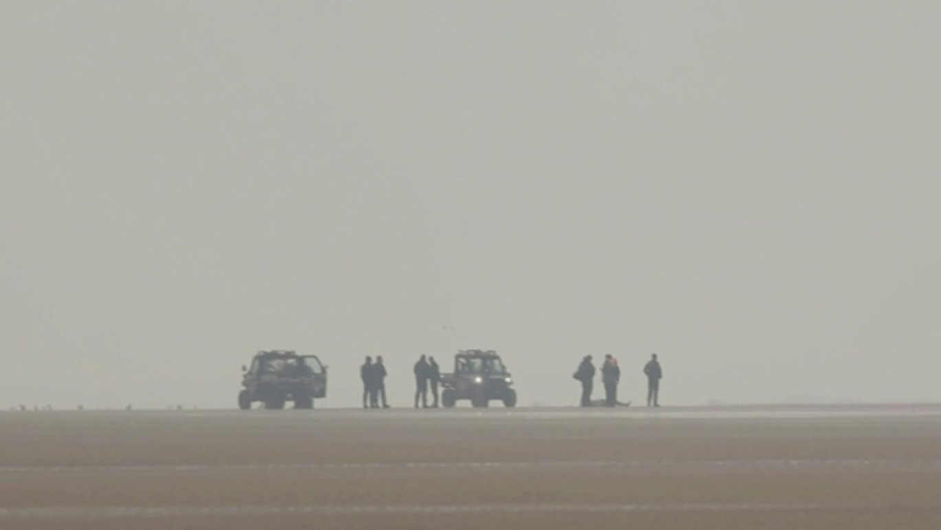 Des policiers et des CRS près d'un corps découvert tôt le matin sur la plage de Sangatte, le 22 janvier 2025 dans le Pas-de-Calais © Sameer Al-DOUMY