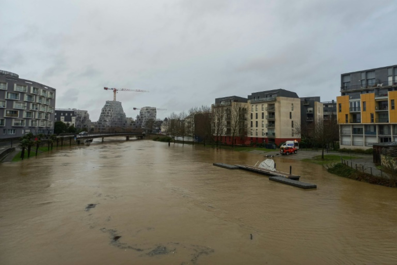 Un homme sur un bateau à côté de voitures garées dans une rue inondée à la suite d'une crue exceptionnelle de l'Ille, le 27 janvier 202 à Rennes, en Ille-et-Vilaine © Damien MEYER