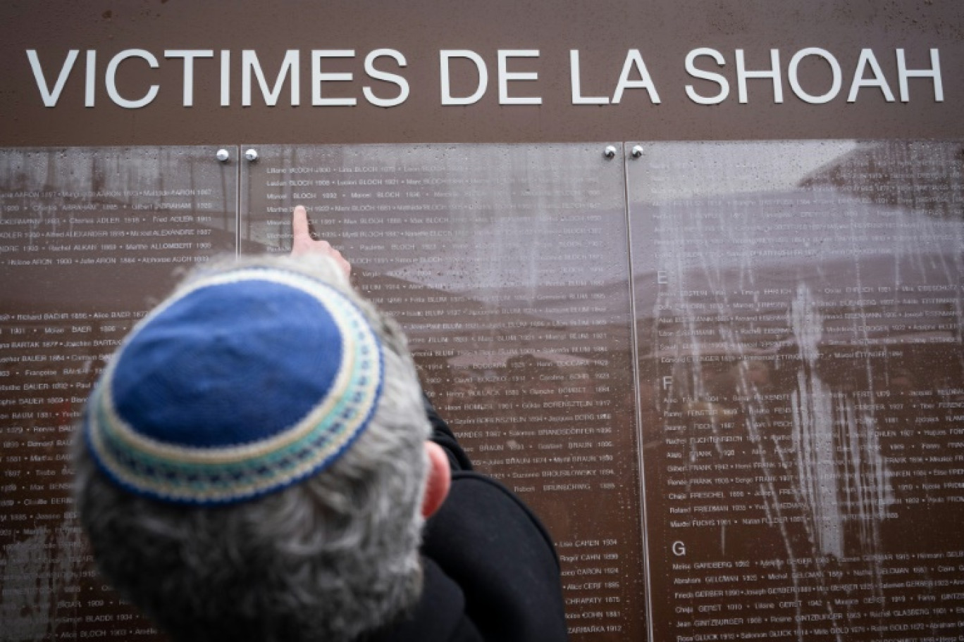 Un homme regarde le mur des noms inauguré à Strasbourg, le 27 janvier 2025 © SEBASTIEN BOZON