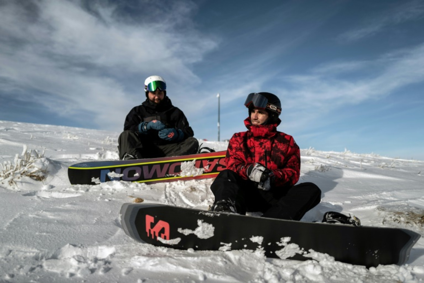 Les réfugiés afghans et snowboarders Musawer (d) et Nizar (g) se préparent à une descente à Viuz-la-Chiesaz, près de la station du Semnoz, dans le massif des Bauges, le 29 janvier 2025 en Haute-Savoie © JEFF PACHOUD