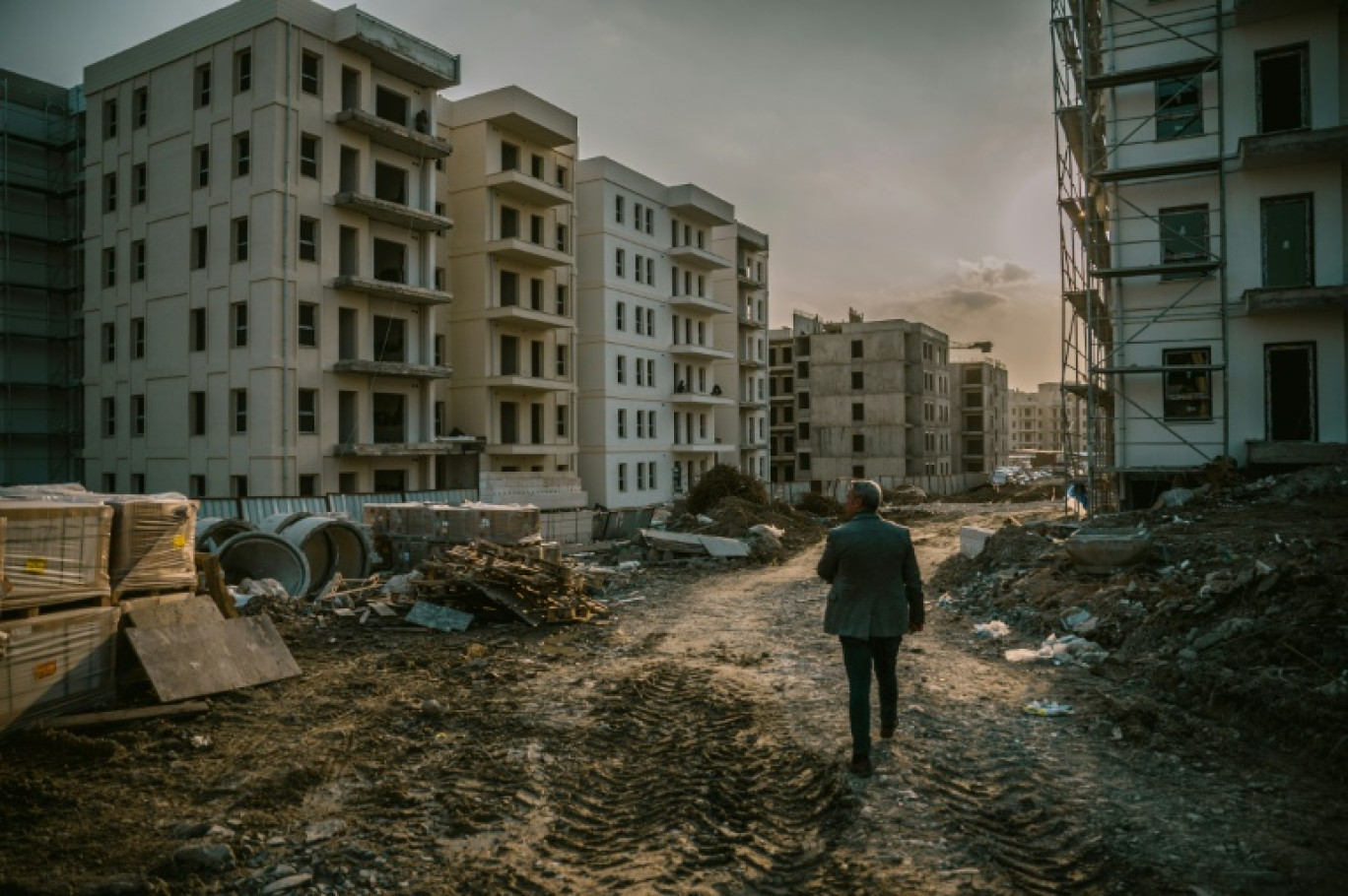 Un homme traverse un chantier de logements sociaux de l'agence publique Toki à Antakya, le 27 janvier 2025 © Ozan KOSE