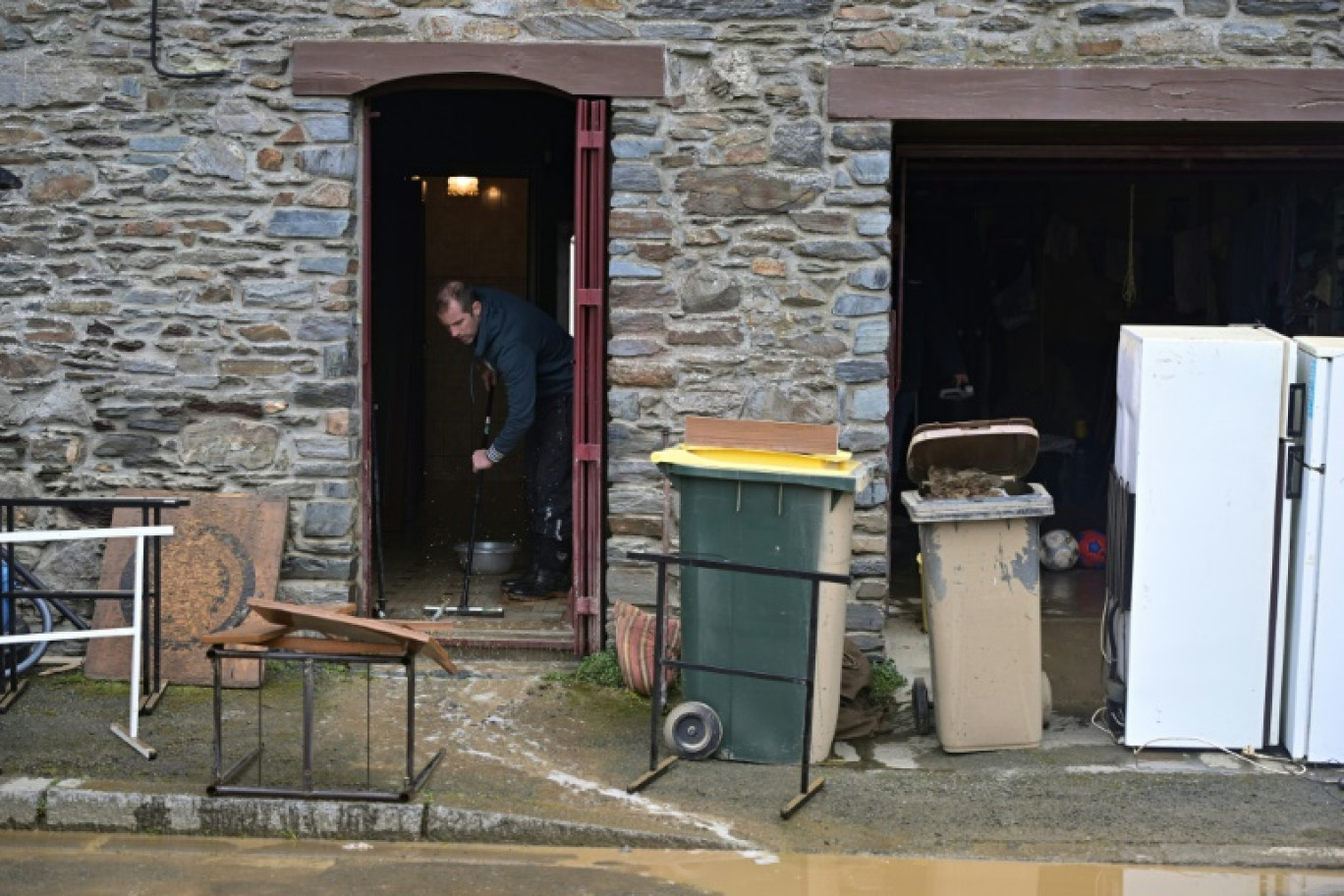 Un habitant nettoie sa maison de la boue et des débris  après les récentes inondations à Guipry-Messac, en Ille-et-Vilaine © Damien MEYER