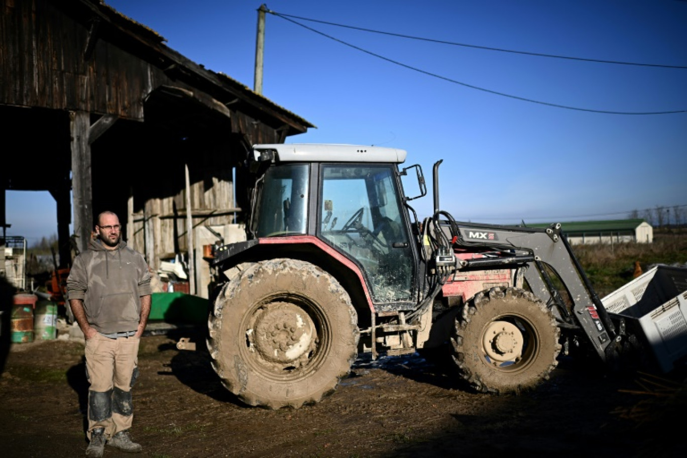 L'éleveur Jérôme Caze pose devant son tracteur dans son exploitation de Meilhan-sur-Garonne, dans le sud-ouest de la France, le 23 janvier 2025 © Christophe ARCHAMBAULT