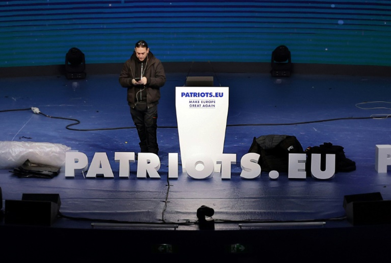 Un technicien installe la scène du meeting du groupe parlementaire Patriotes pour l'Europe, le 7 février 2025 à Madrid © Thomas COEX