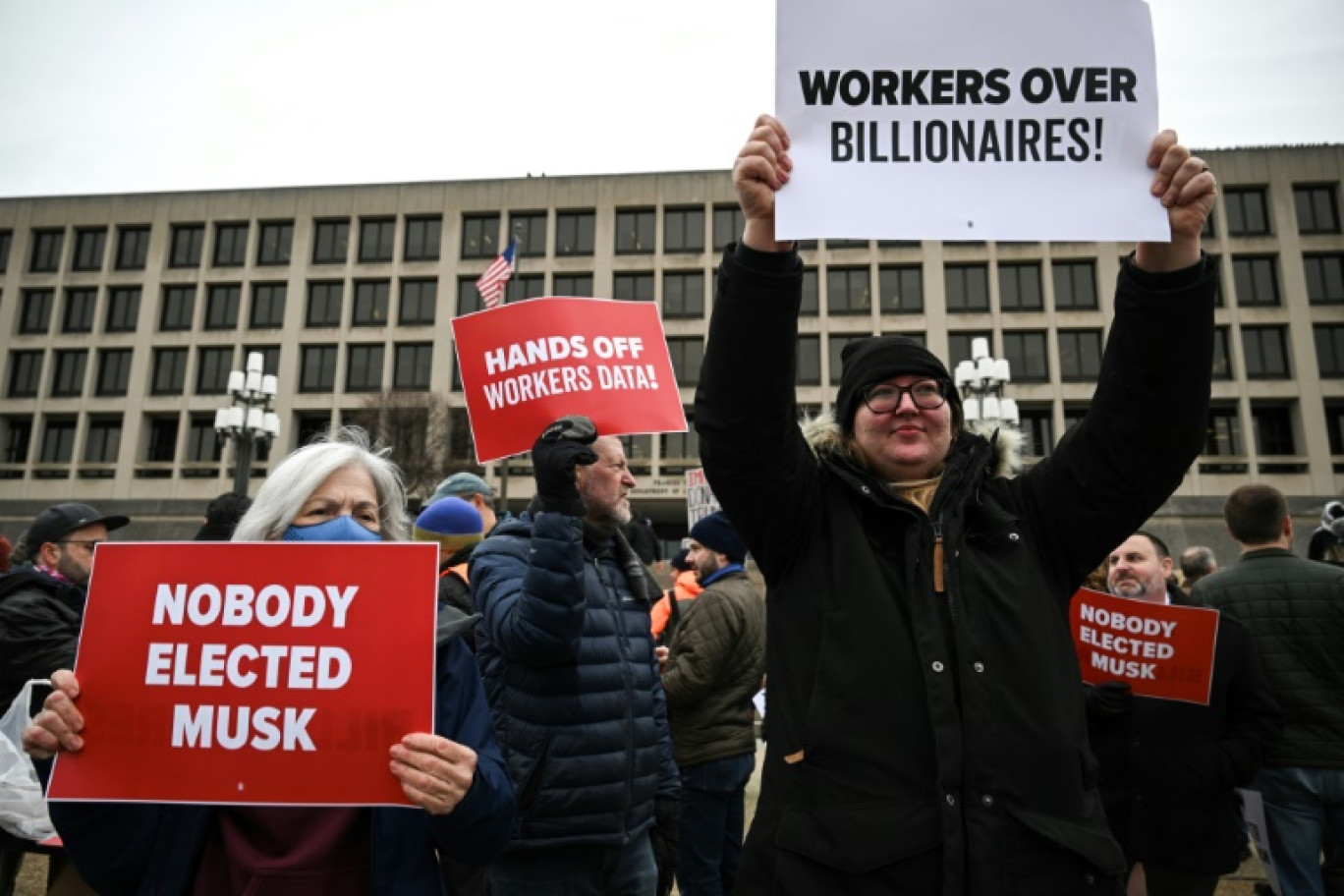 Des manifestants brandissent des pancartes lors d'une protestation contre le président américain Donald Trump et le Doge, la commission confiée à Elon Musk, devant le ministère américain du Travail près du Capitole à Washington le 5 février 2025 © Drew ANGERER