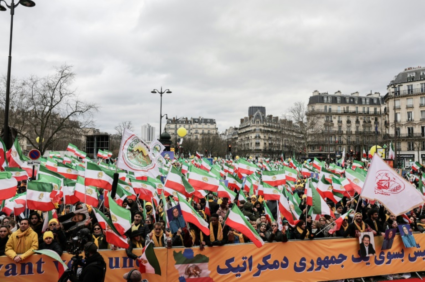 Des partisans des Moudjahidines du peuple d'Iran brandissent l'ancien drapeau de l'État iranien (de 1964 à 1979) pour réclamer la justice, les droits de l'homme et la liberté pour le peuple iranien à Paris, le 8 février 2025 © Thibaud MORITZ