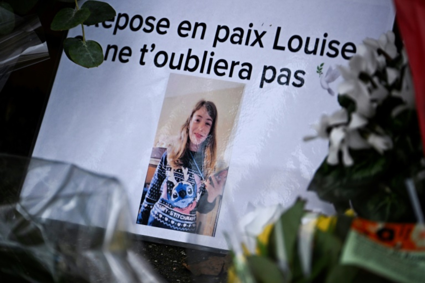 Une photographie de Louise accompagnée de bouquets déposées devant son collège d'Epinay-sur6orge(Essonne) le 8 février 2025 © JULIEN DE ROSA