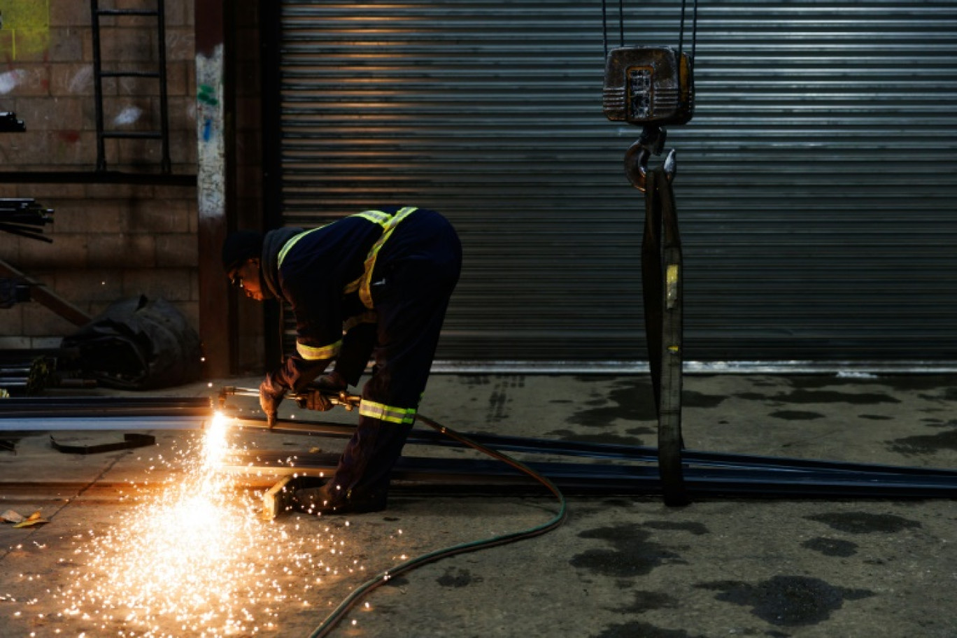 Un employé de North York Iron, un fournisseur d'acier à Toronto, découpe une pièce en acier, le 11 février 2025 au Canada © Cole BURSTON