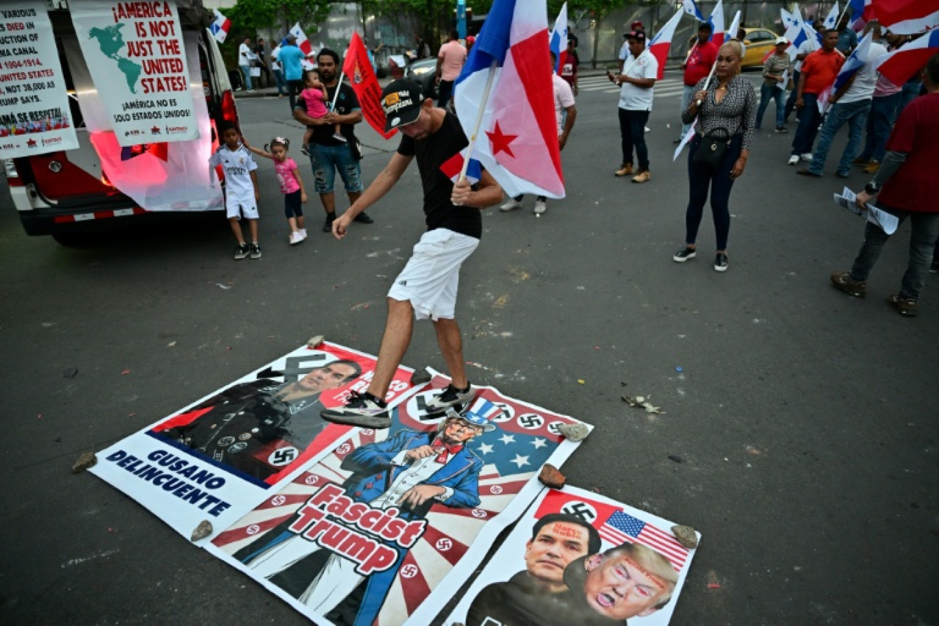 Un manifestant marche sur une affiche représentant le secrétaire d'État américain Marco Rubio et le président américain Donald Trump alors qu'il participe à une manifestation contre la visite de M. Rubio à Panama le 1er février 2025 © MARTIN BERNETTI