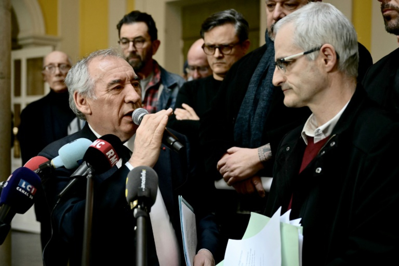 Le Premier ministre français François Bayrou (G) s'adresse à la presse après une rencontre avec des membres du collectif des victimes de violences de Notre-Dame-de-Betharram et son porte-parole Alain Esquerre (D) à la mairie de Pau, dans le sud-ouest de la France, le 15 février 2025 © Philippe Lopez