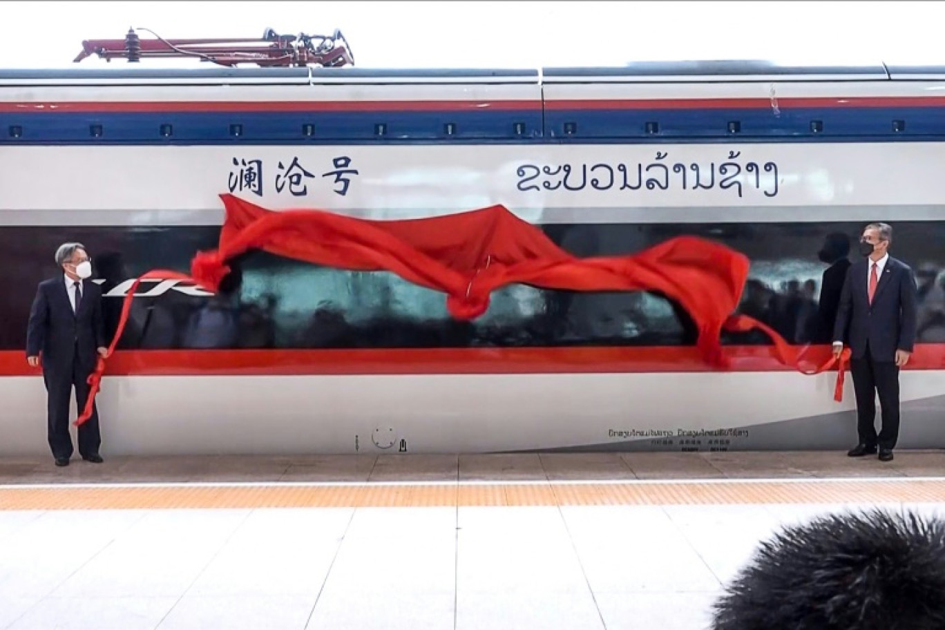 Capture d'écran de la télévision Lao National TV, prise le 16 octobre 2021, montrant des officiels laotien et chinois, réunis à Ventiane, à l'occasion du lancement de la première ligne de chemin de fer au Laos © STR