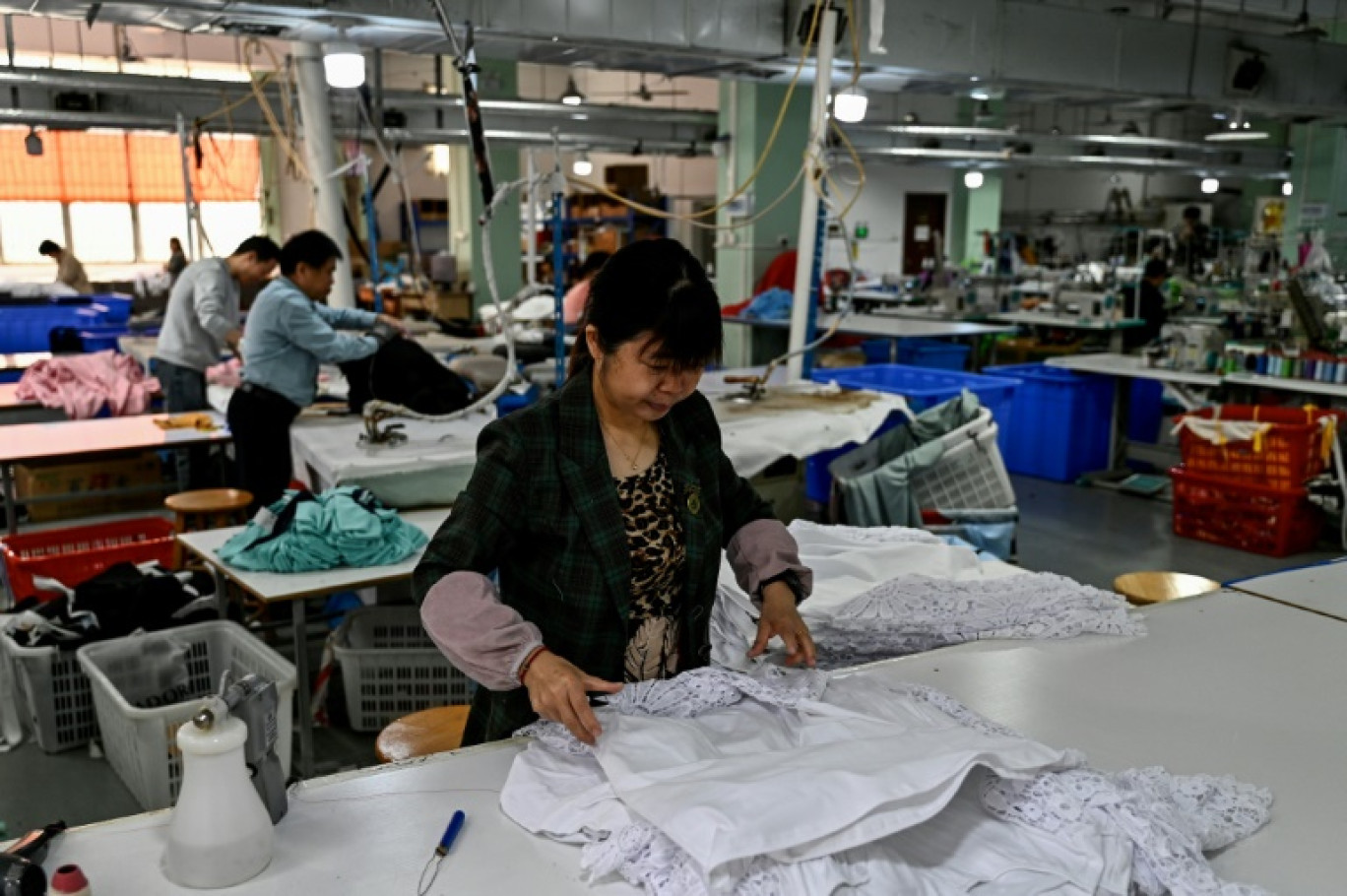 Des employés dans un atelier de couture de vêtements à Canton, dans la province chinois du Guangdong, le 20 février 2025 © Pedro PARDO