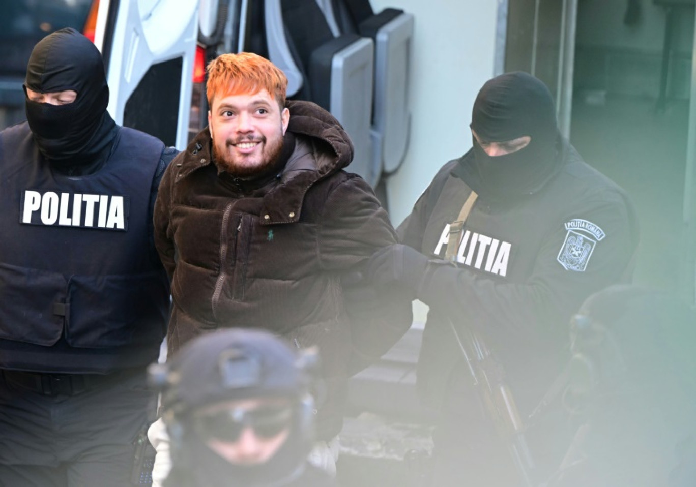 Des policiers roumains escortent Mohammed Amra pour le conduire à la cour d'appel de Bucarest le 23 février 2025 © Daniel MIHAILESCU