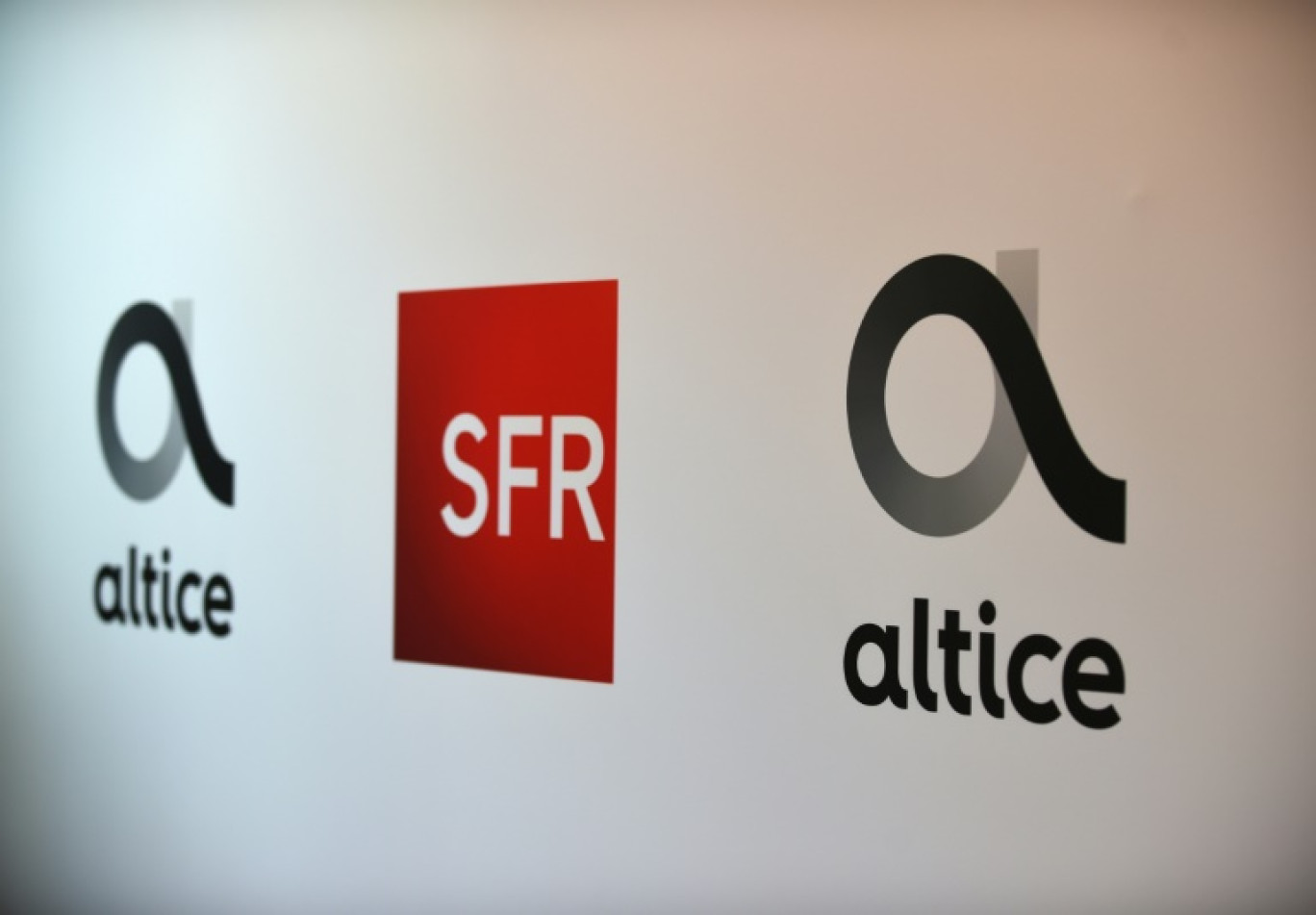 Logos d'Altice et SFR, lors d'une conférence de presse d'Altice France à Paris le 11 avril 2019 © ERIC PIERMONT