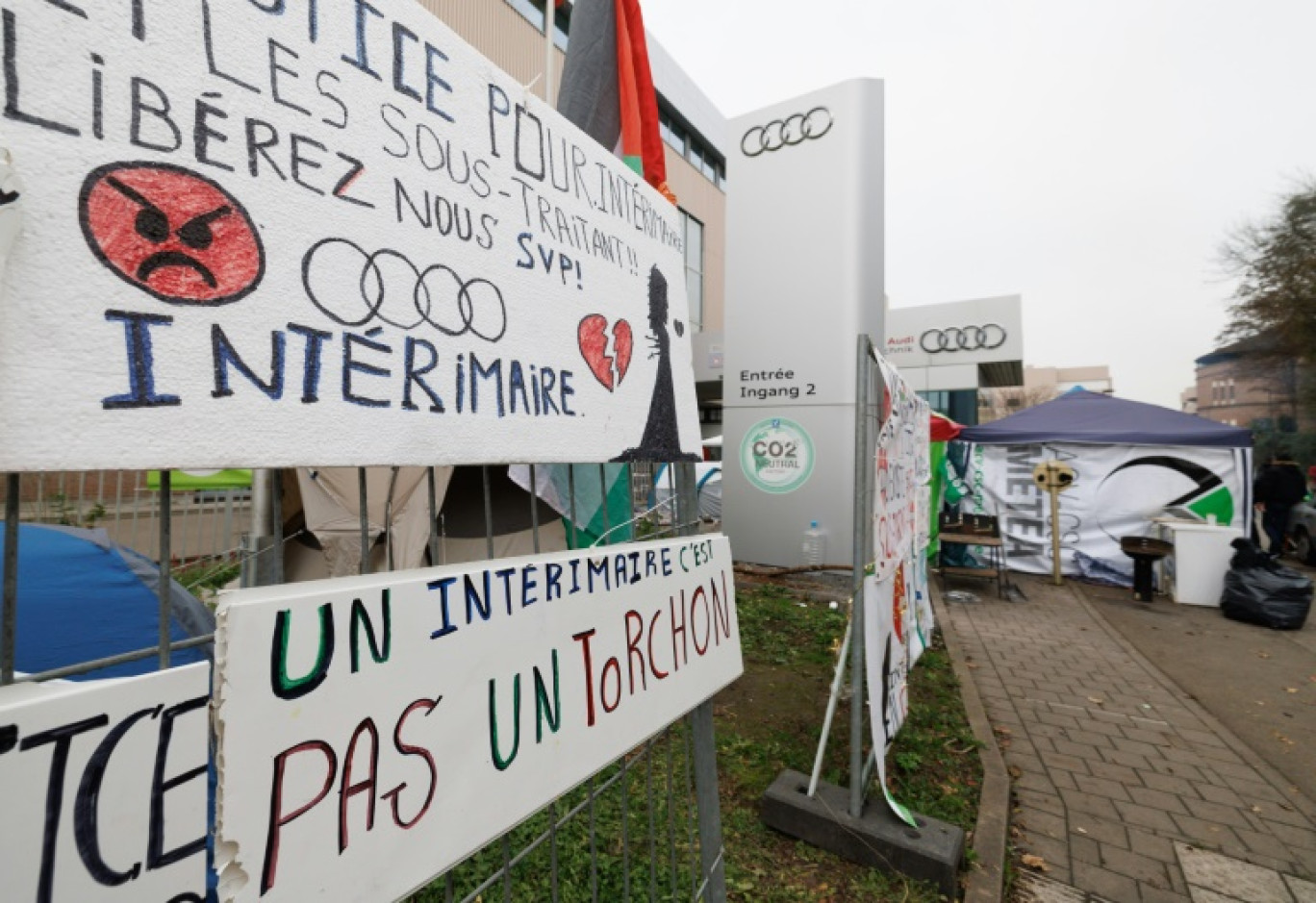 Des panneaux et banderoles devant l'usine automobile Audi de Vorst-Forest, à Bruxelles, le 13 novembre 2024 © BENOIT DOPPAGNE