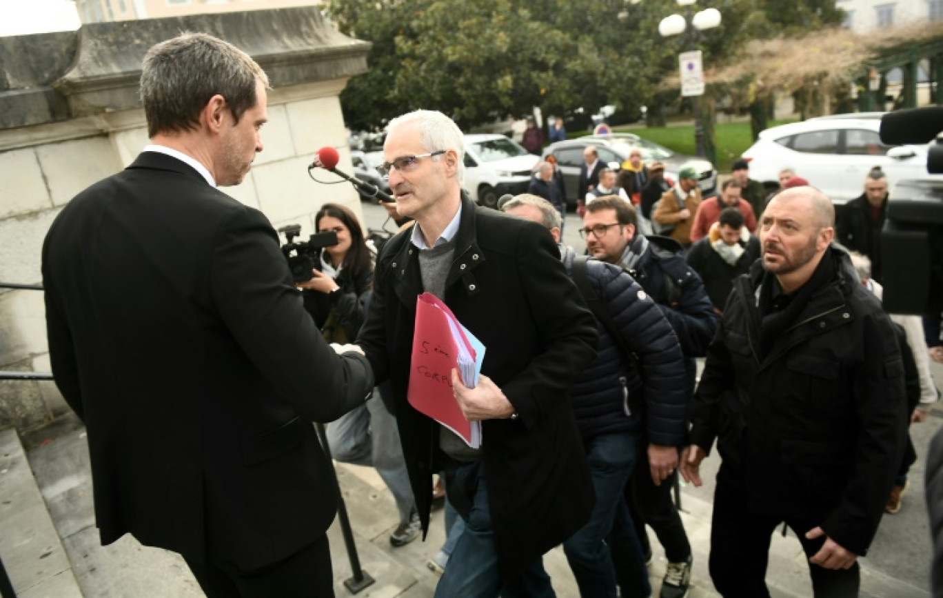 Le porte-parole du collectif des victimes de Bétharram, Alain Esquerre (au centre), serre la main du procureur de la République de Pau, Rodolphe Jarry (L), sur les marches du palais de justice le 27 février 2025 © Gaizka IROZ