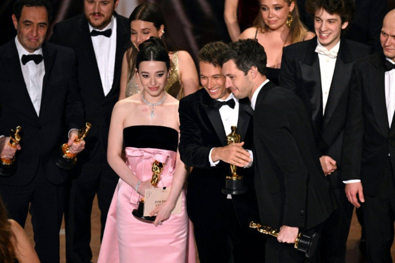 Le producteur américain Alex Coco, avec le réalisateur Sean Baker et l'actrice Mikey Madison avec la statuette du meilleur film, à Hollywood, le 2 mars 2025 © Patrick T. Fallon