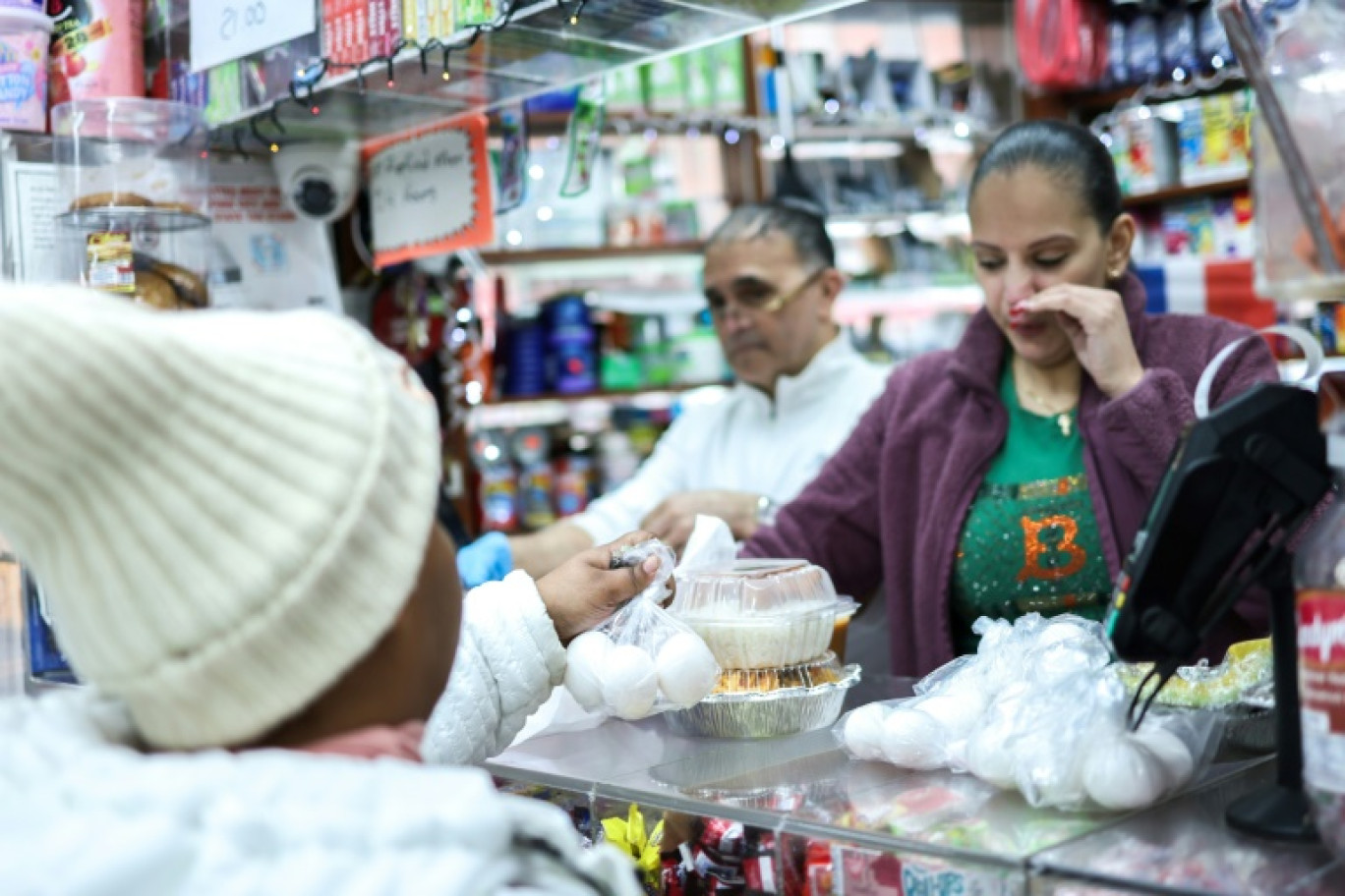 Une cliente achète trois oeufs emballés dans un sachet plastique, dans une "bodega" du Bronx, à New York, le 27 février 2025 © CHARLY TRIBALLEAU