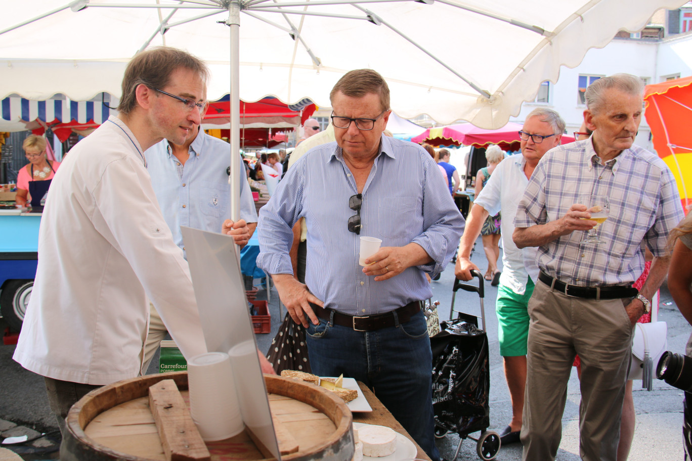 Sur le marché d’Arras, Jean-François Dubois présente à Philippe Rapeneau, président de la Communauté urbaine d’Arras, ses fromages médaillés.