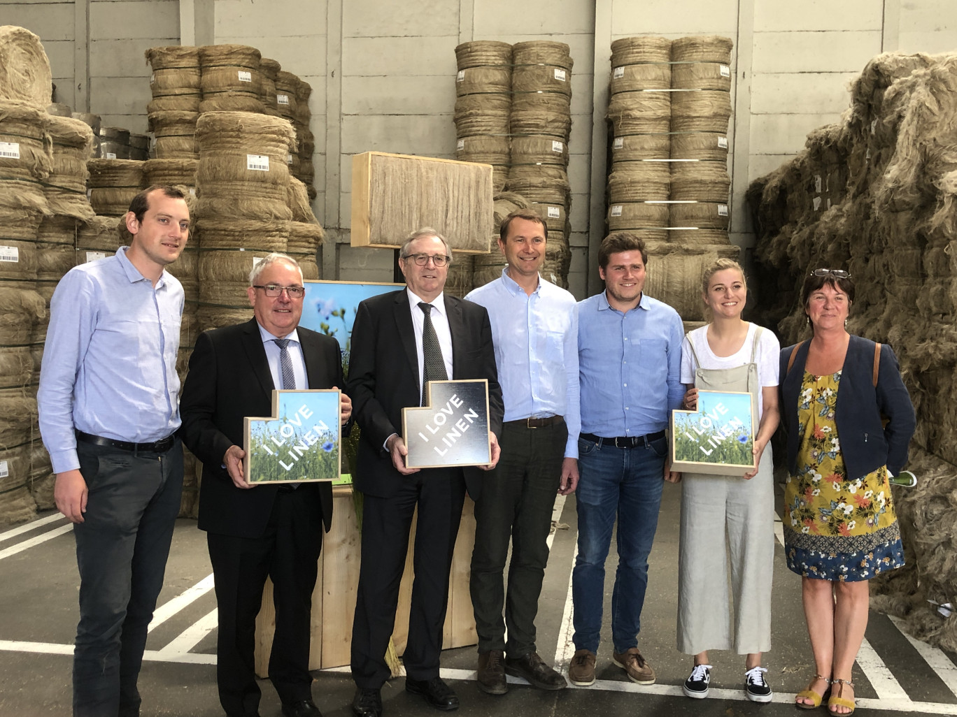 André Figoureux et Philippe Vasseur entourés par les tailleurs du territoire et posant devant le lin entreposé.