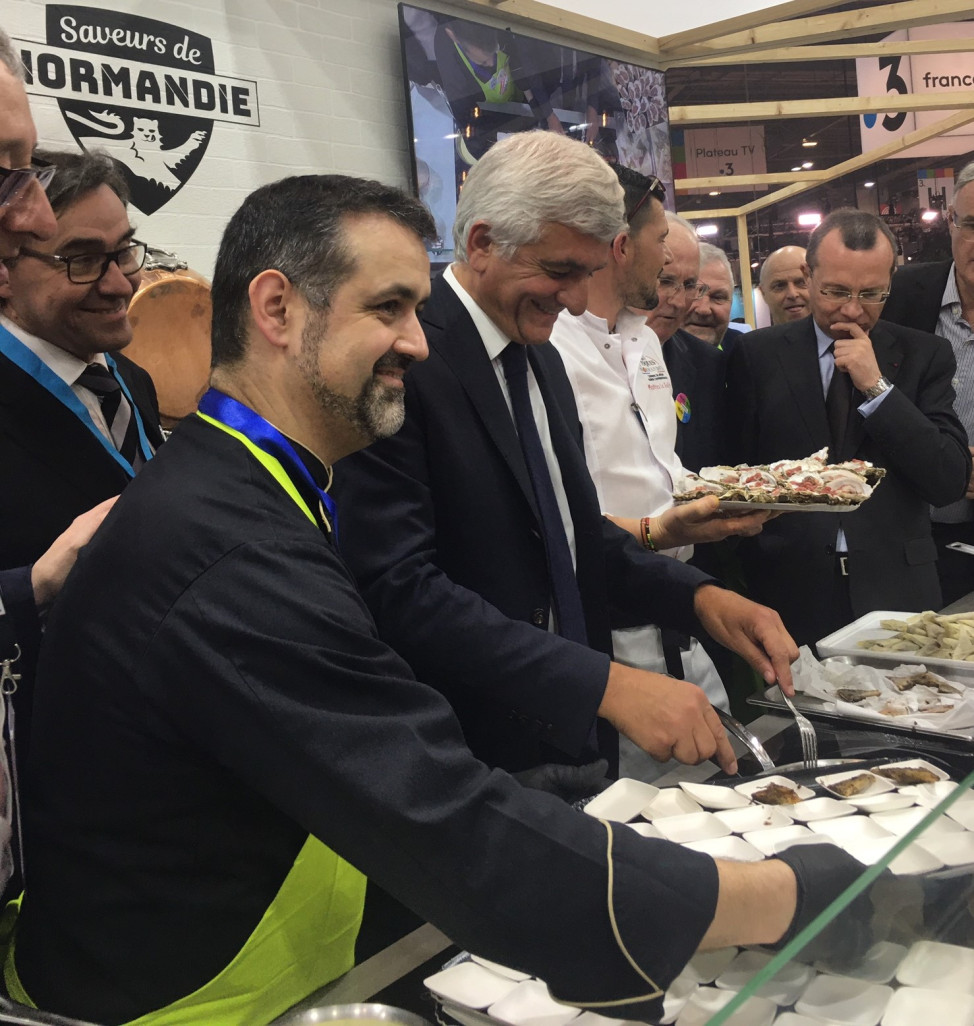 Crédit photo : AgGu  /Aletheia Press  ,« Normandie 1 Sur le stand du Show’Dron Hervé Morin s’initie à une recette du chef Paulo Ferreira. » 